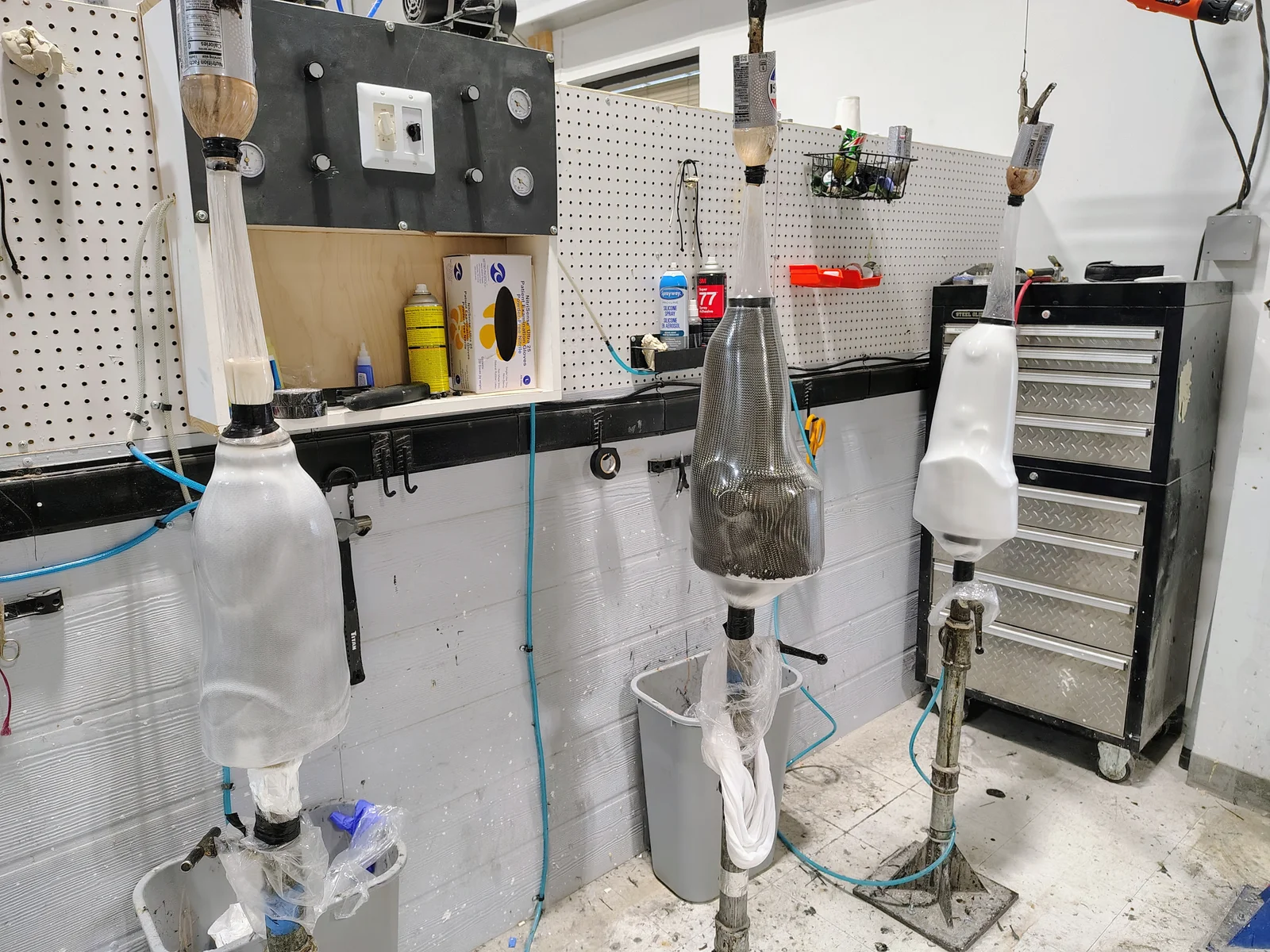 Several prosthetic sockets standing at fabrication workstations