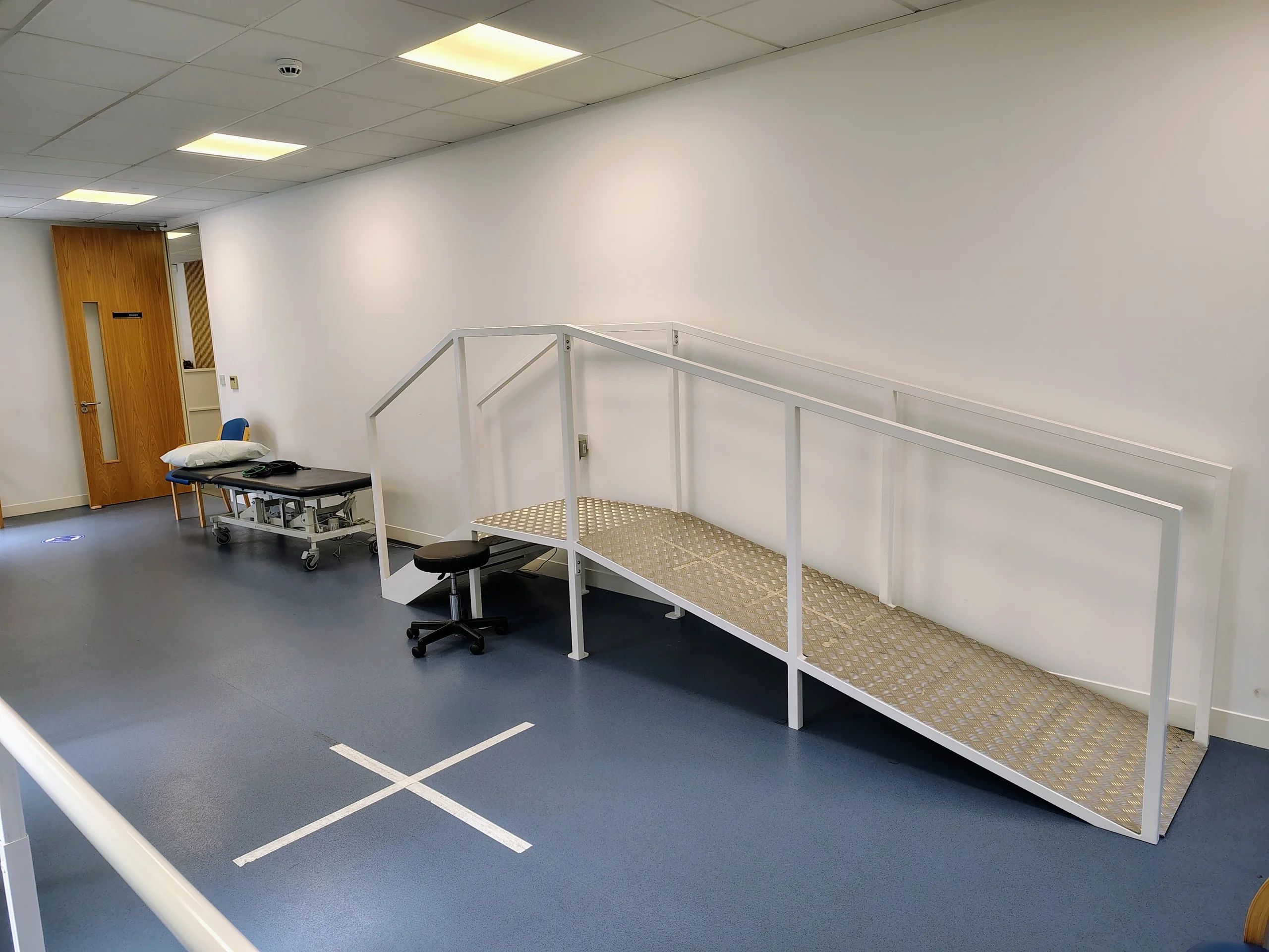 Practice ramp and steps with handrails inside the rehabilitation gym.