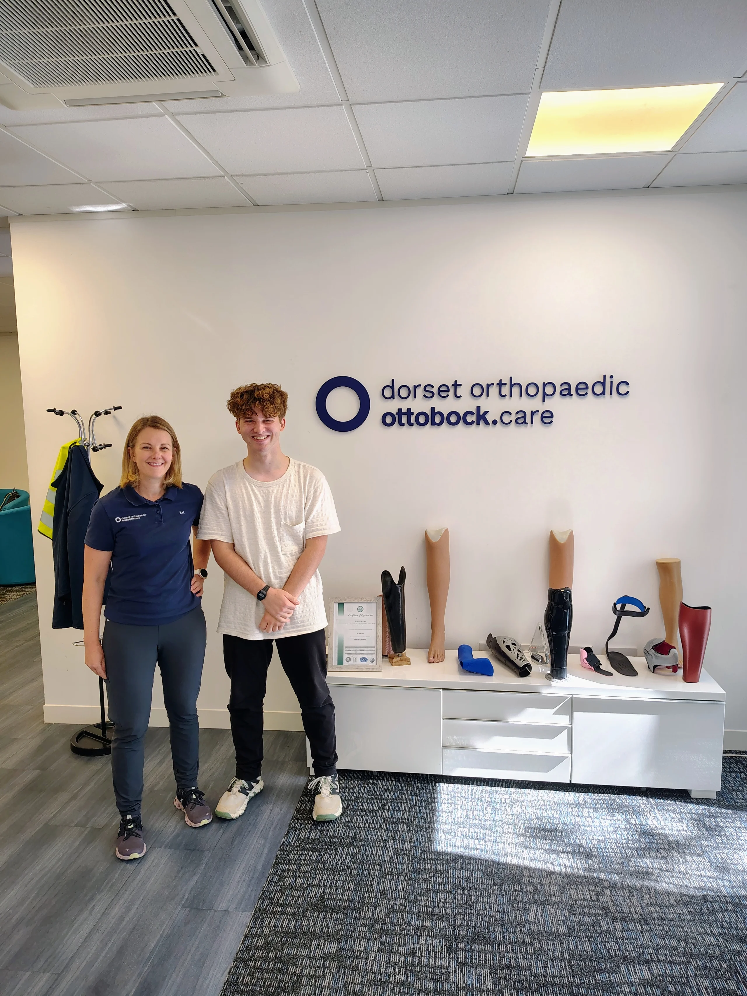 The author and the physiotherapist standing beside the Dorset Orthopaedic display in Amersham.