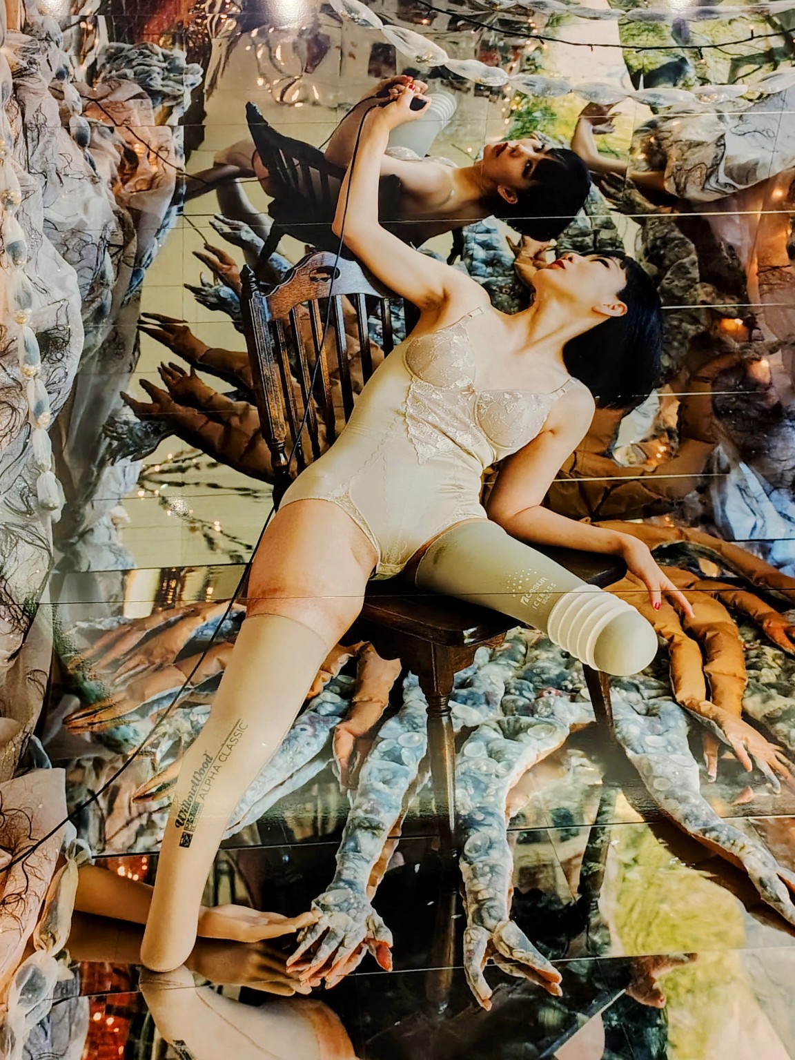 Detail of a tree of life photograph, showing the artist, her prostheses, and reflected handsewn forms.